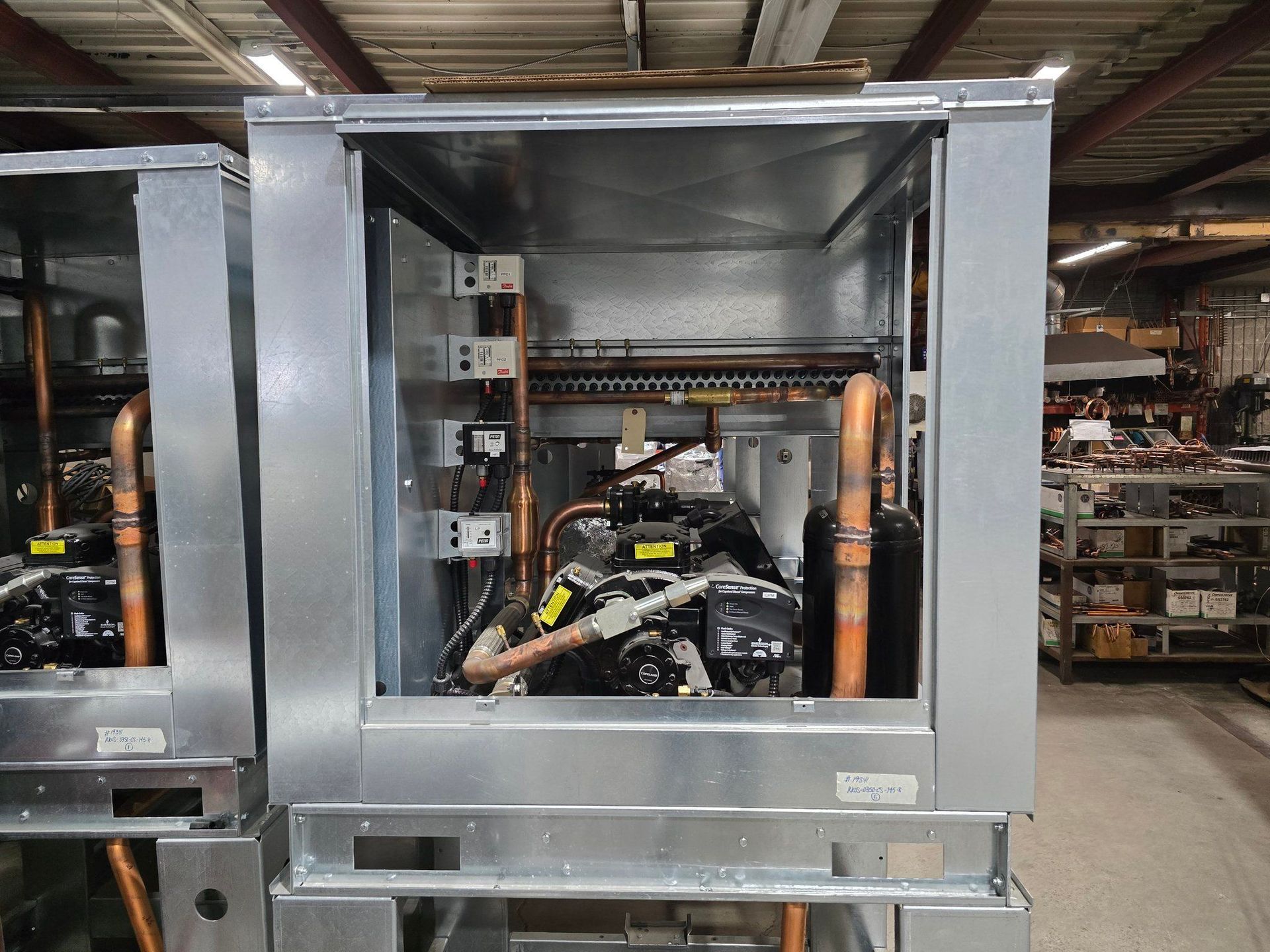 Une machine est en cours de construction dans une usine avec des tuyaux en cuivre qui en sortent.