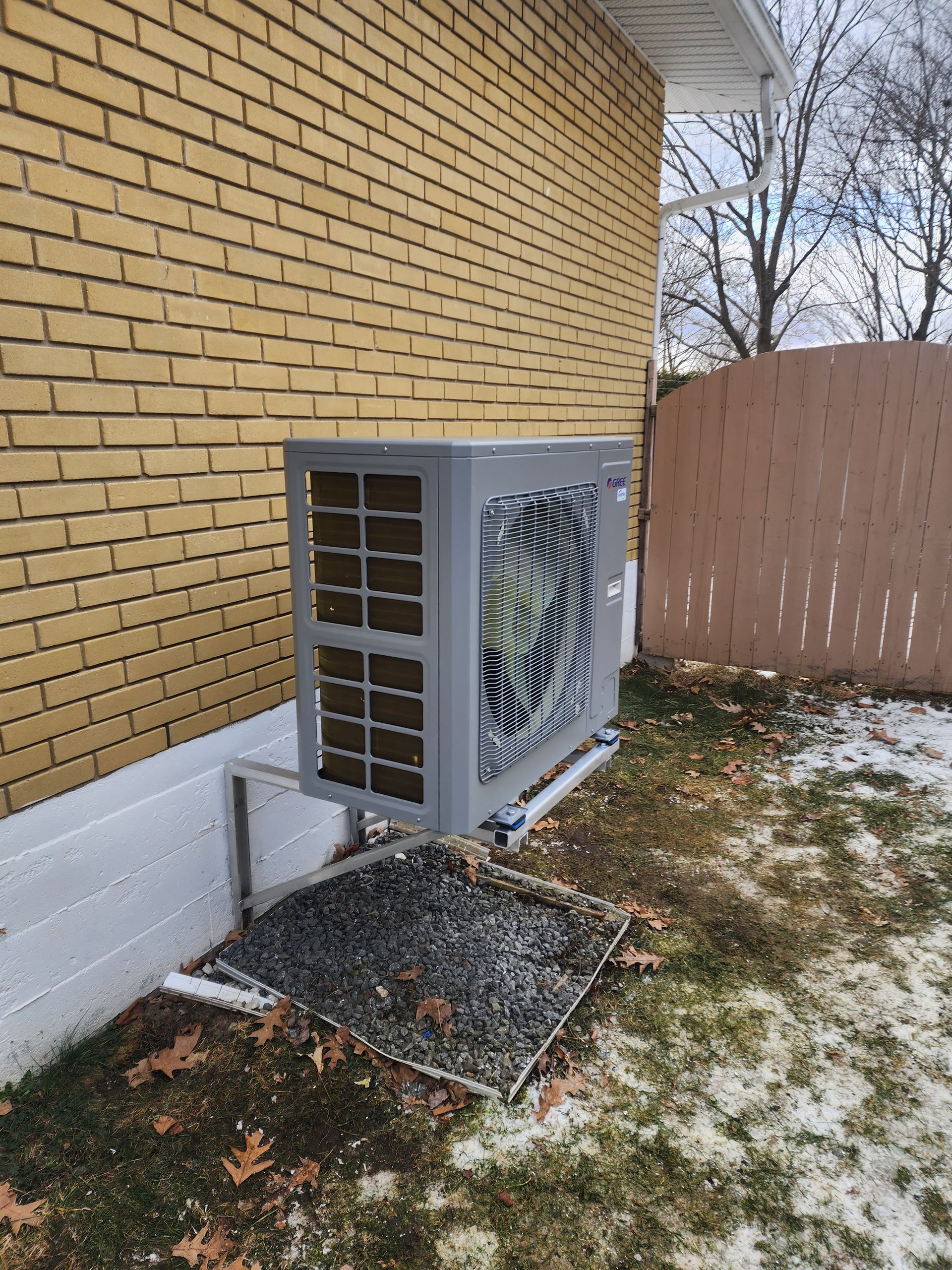 Un grand climatiseur est installé sur le côté d'un bâtiment en briques.