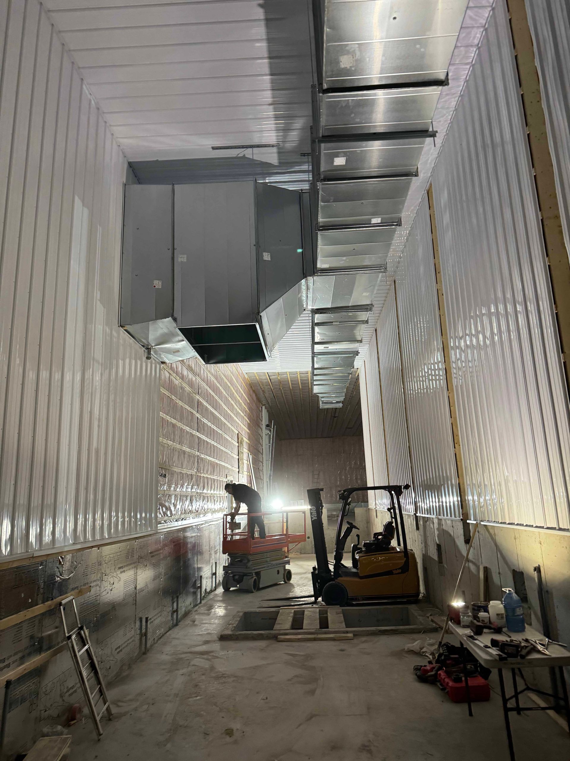 Un chariot élévateur roule dans un couloir d'un bâtiment en construction.