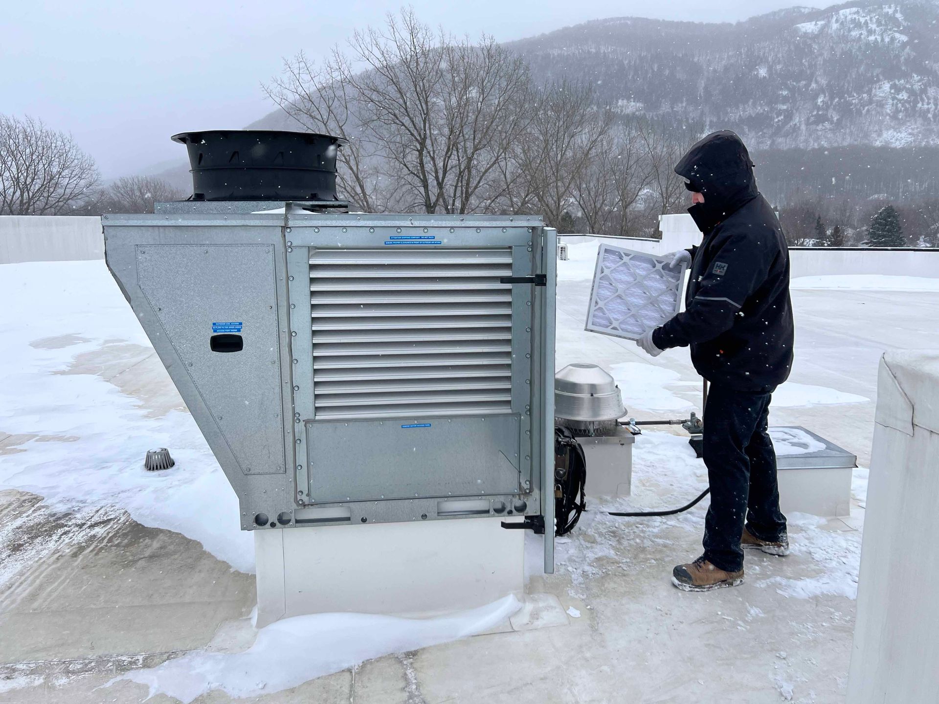 Un homme se tient devant une machine dans la neige
