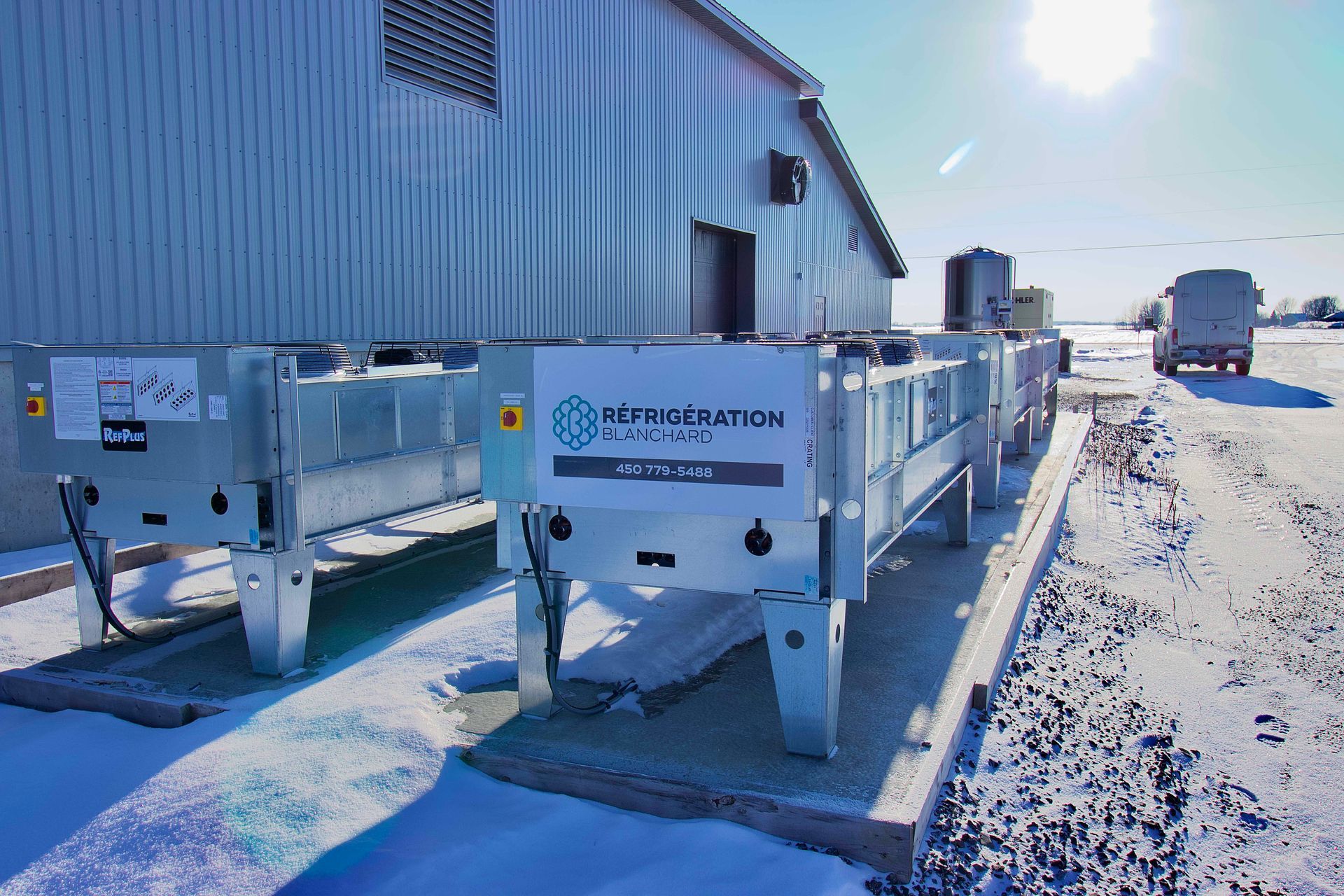 Une rangée de glacières est posée à l'extérieur d'un bâtiment dans la neige.