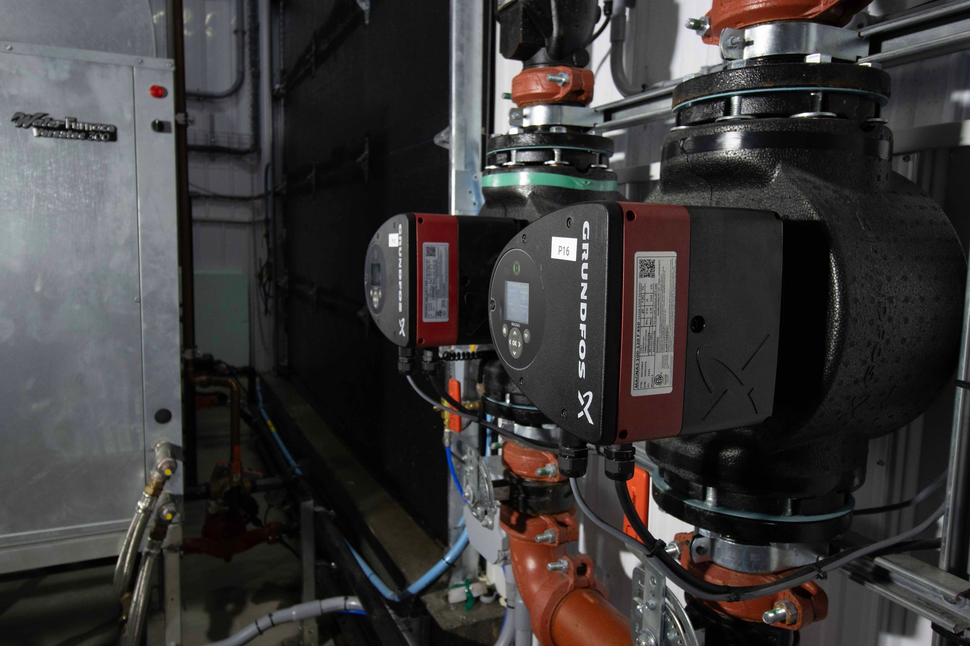 Une pièce avec beaucoup de tuyaux et de pompes