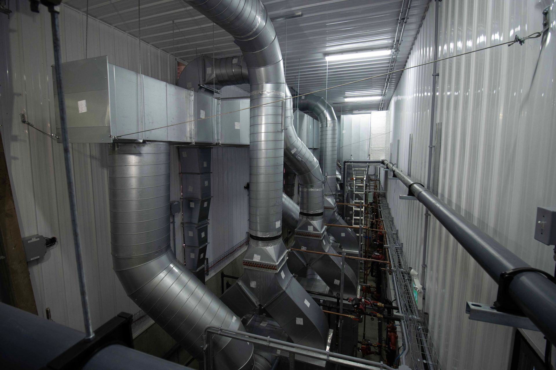 Une pièce avec beaucoup de tuyaux sortant du plafond.