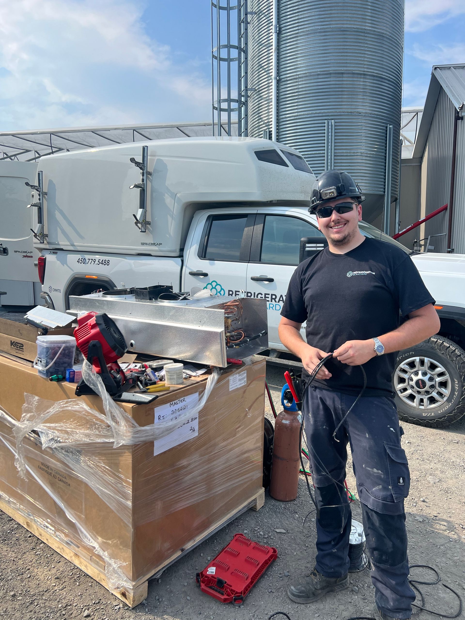 Un homme se tient devant un camion sur un parking.
