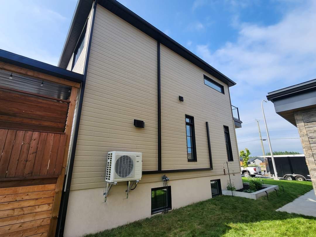 Une grande maison avec un grand climatiseur sur le côté.