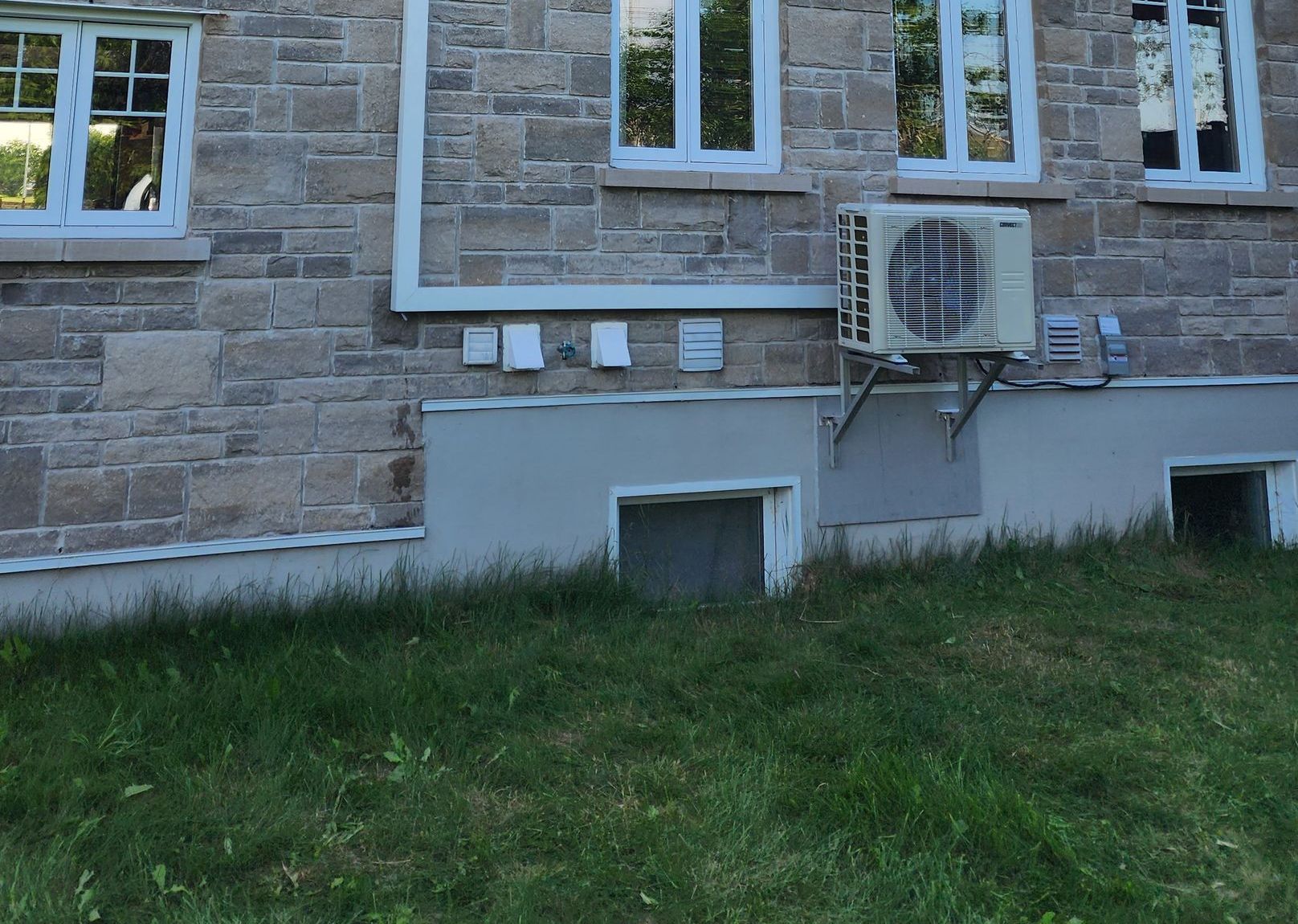 Un bâtiment en brique avec un grand climatiseur sur le côté