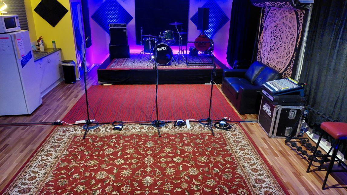 A room with a red rug and a stage in the middle