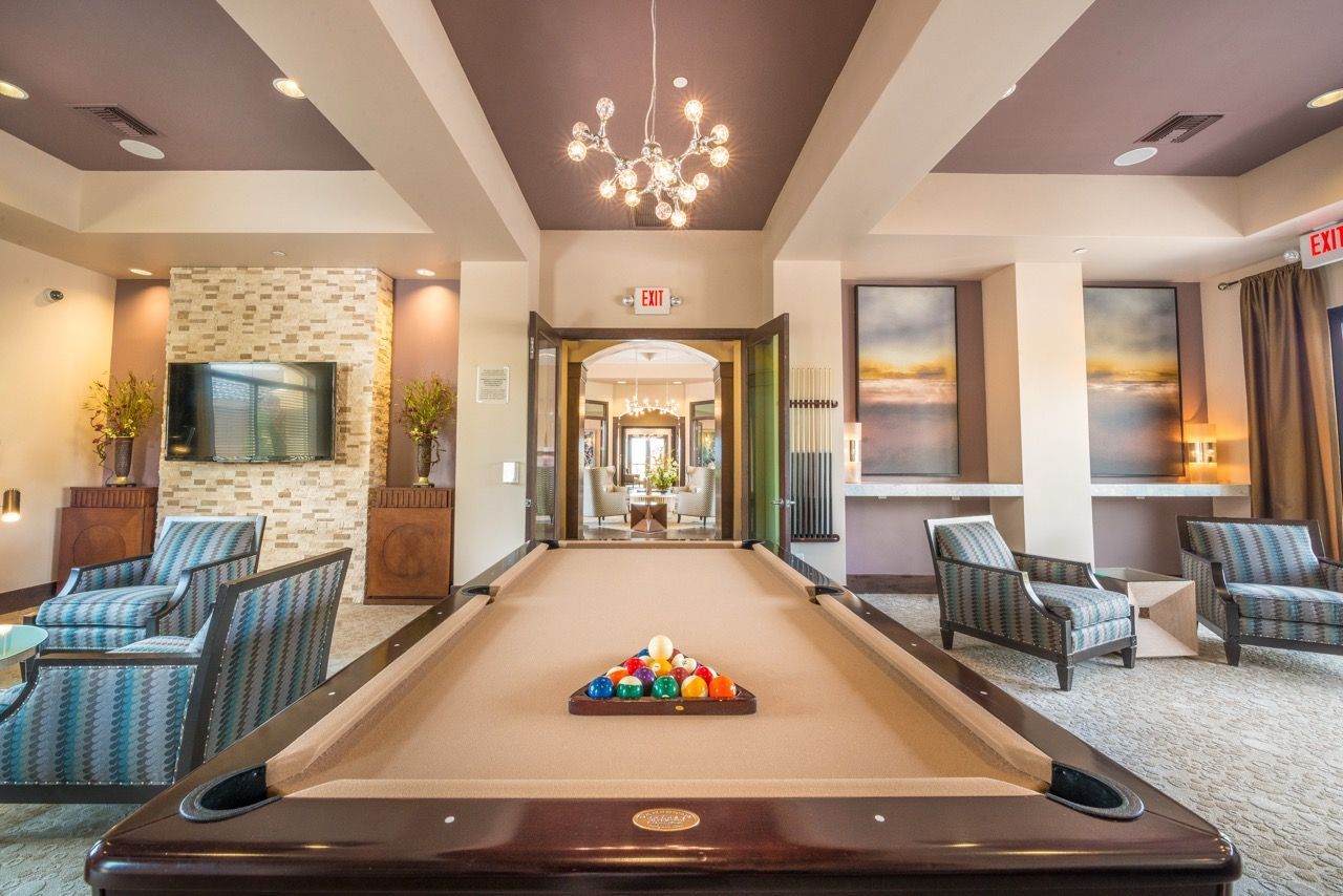 Lobby lounge with a pool table, contemporary seating, and pendant lighting.