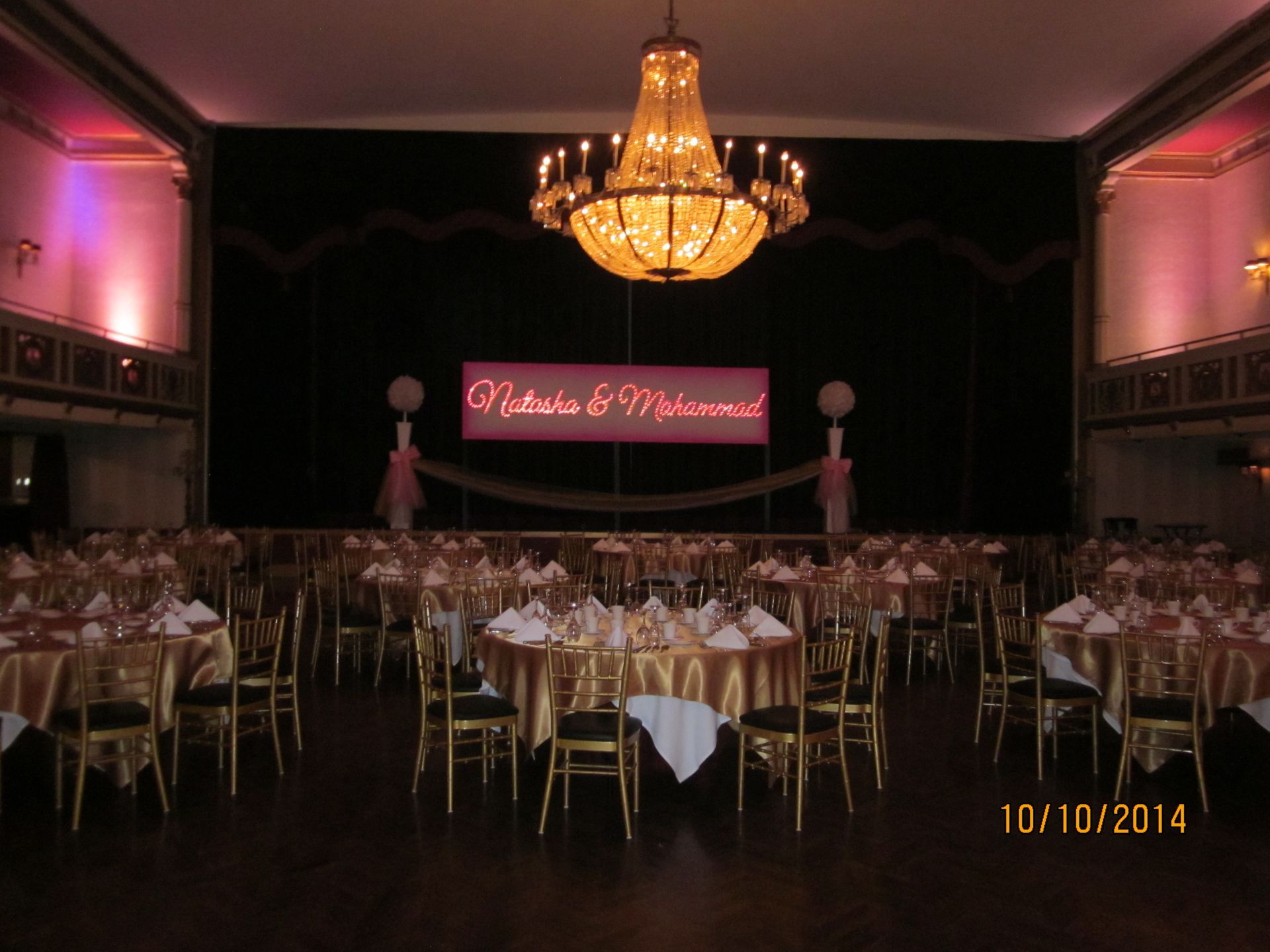 A large room with tables and chairs set up for a wedding reception