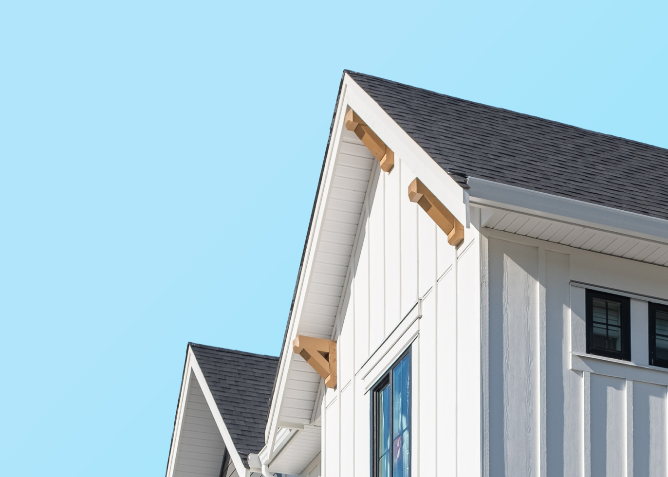 A white house with a recently completed residential roof project