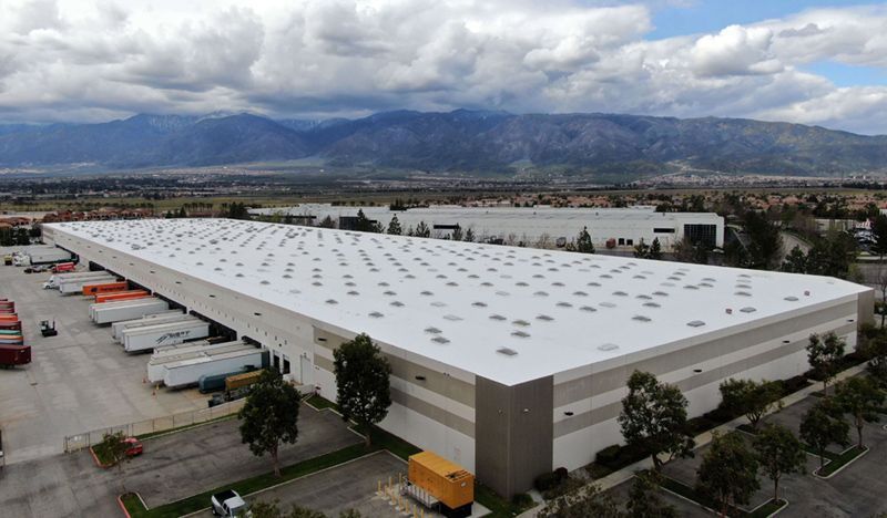 Blue house with gray roof, under blue sky.
