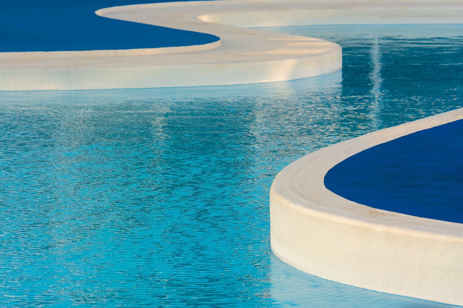 Blue water pool with white curved borders.
