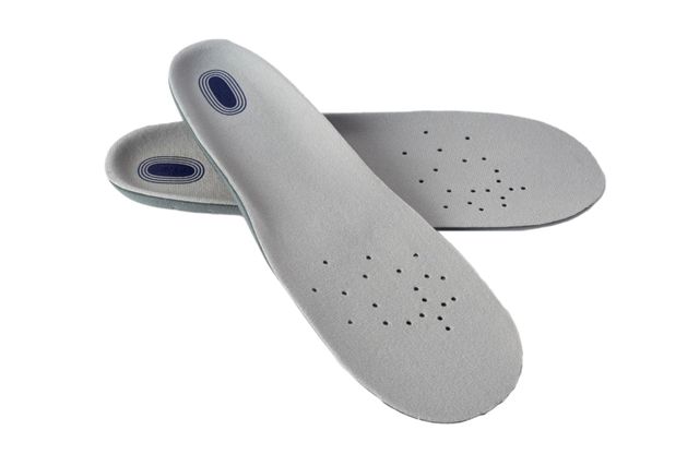 Un paio di solette per scarpe grigio chiaro con fori di ventilazione e logo blu scuro sul tallone, isolate su sfondo bianco.