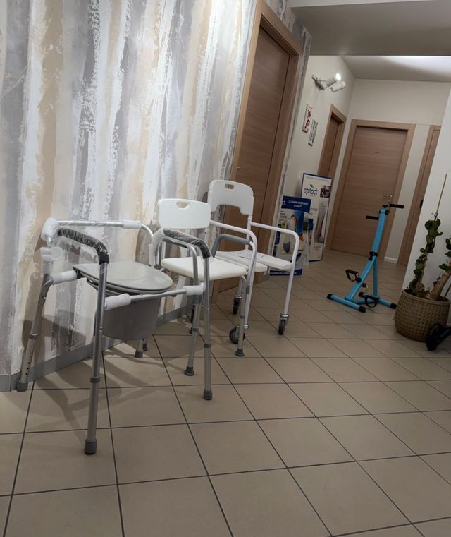 Una persona con i guanti modella una soletta ortopedica in pelle su misura utilizzando un utensile di levigatura motorizzato.