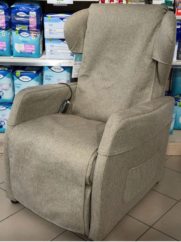 Una testiera beige trapuntata su un letto con un coprimaterasso trapuntato bianco e cuscini quadrati alternati bianchi e marroni.