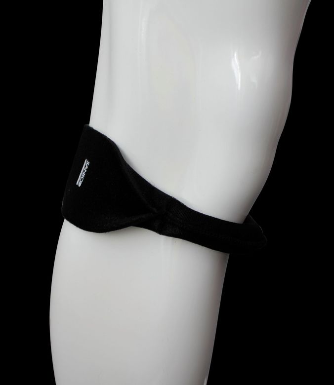 Una persona che indossa un corsetto ortopedico strutturato di colore beige sopra una canottiera bianca, vista da dietro.