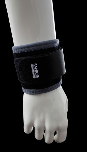 Una persona indossa una cintura addominale compressiva nera in rete sopra una maglietta bianca, allacciando la chiusura frontale con le mani.