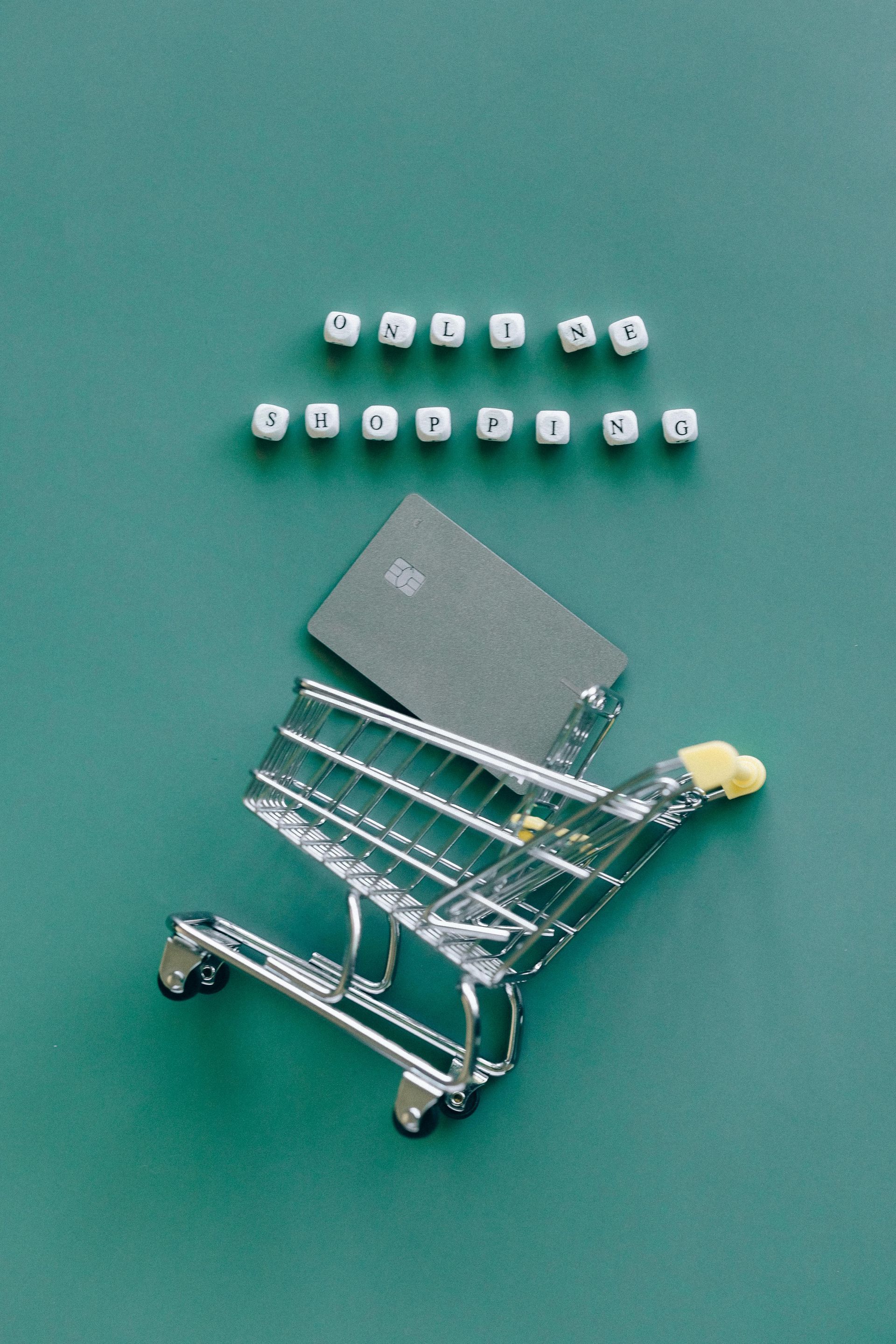 Carrinho de compras com um cartão de crédito em um fundo azul-petróleo; palavras