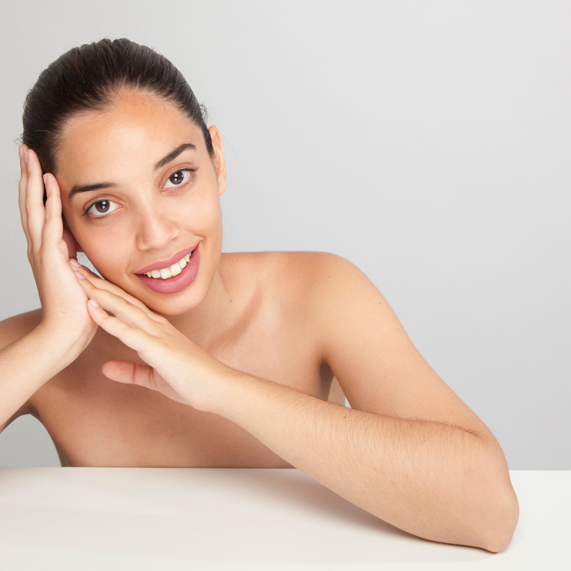 A woman sitting at a table with her hands on her face