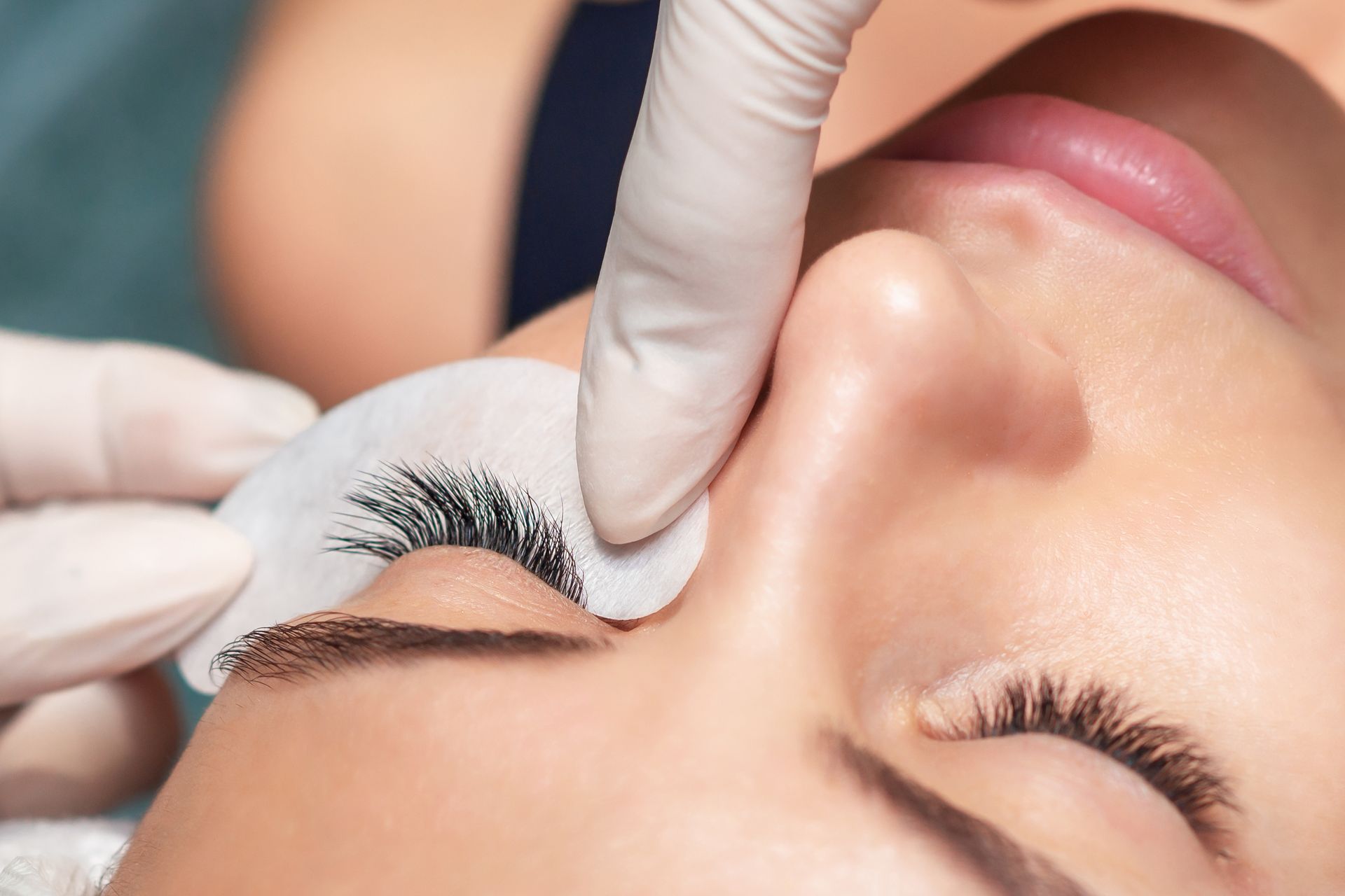 A woman is getting her eyelashes done at a beauty salon.
