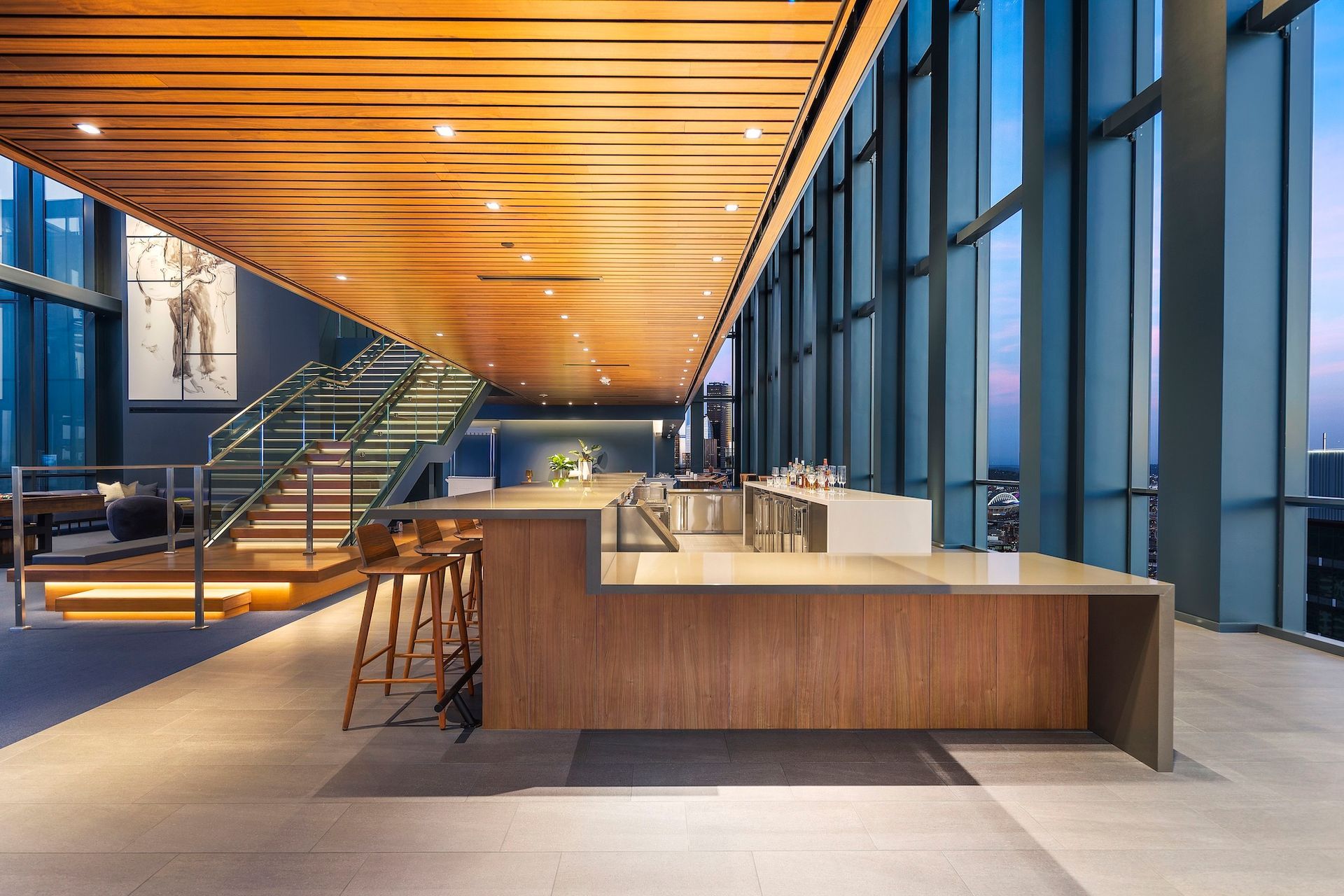 Modern office lobby with wood ceiling, glass walls, and a large reception desk