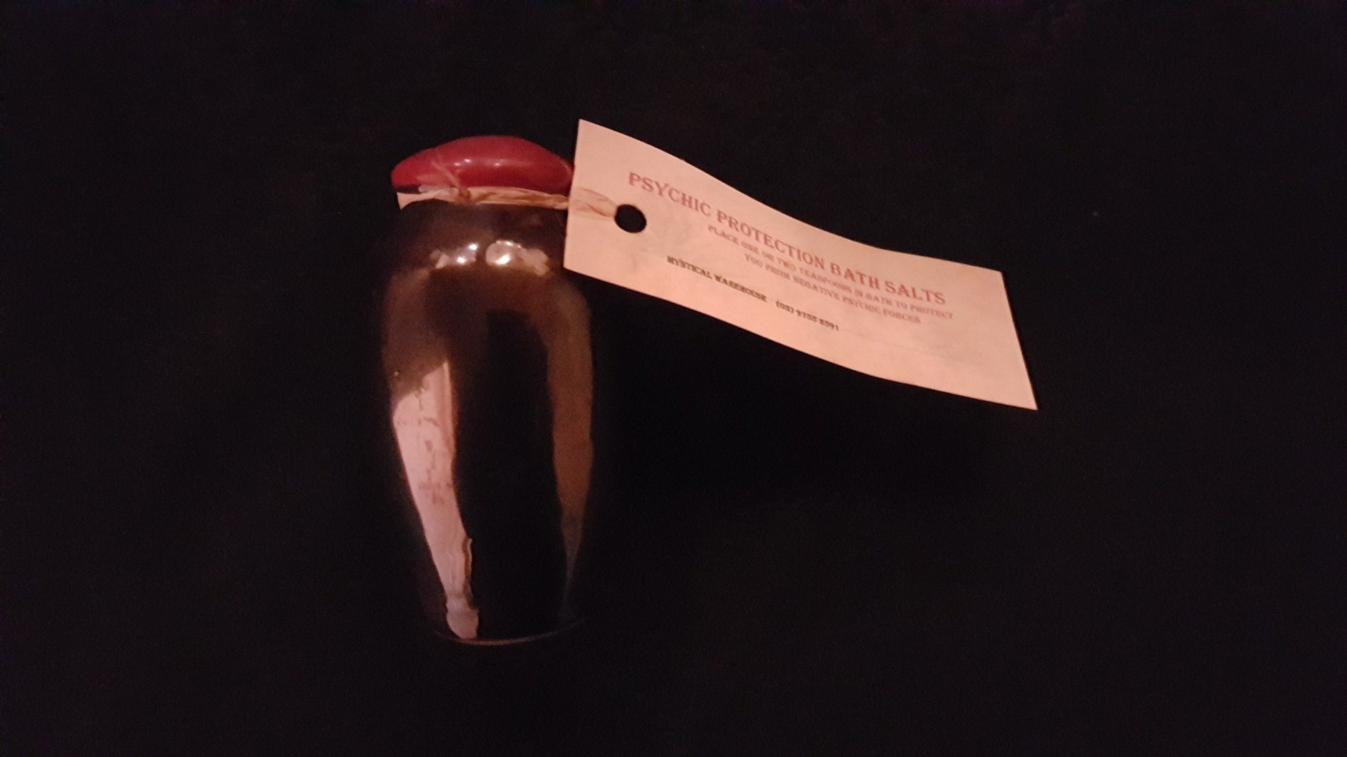 A small jar with a tag attached to it