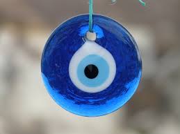 A blue and white evil eye hanging from a string.