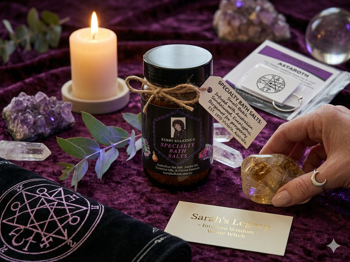 Purple altar with candle, crystals, a black jar, a tarot deck, and a hand holding a stone