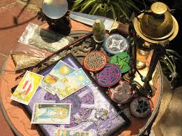 A table with tarot cards , candles , and a picture on it.