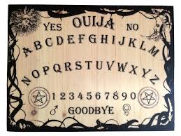 A wooden ouija board with the alphabet and numbers on it.