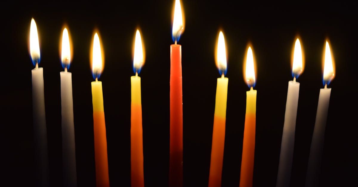 A row of lit candles on a black background