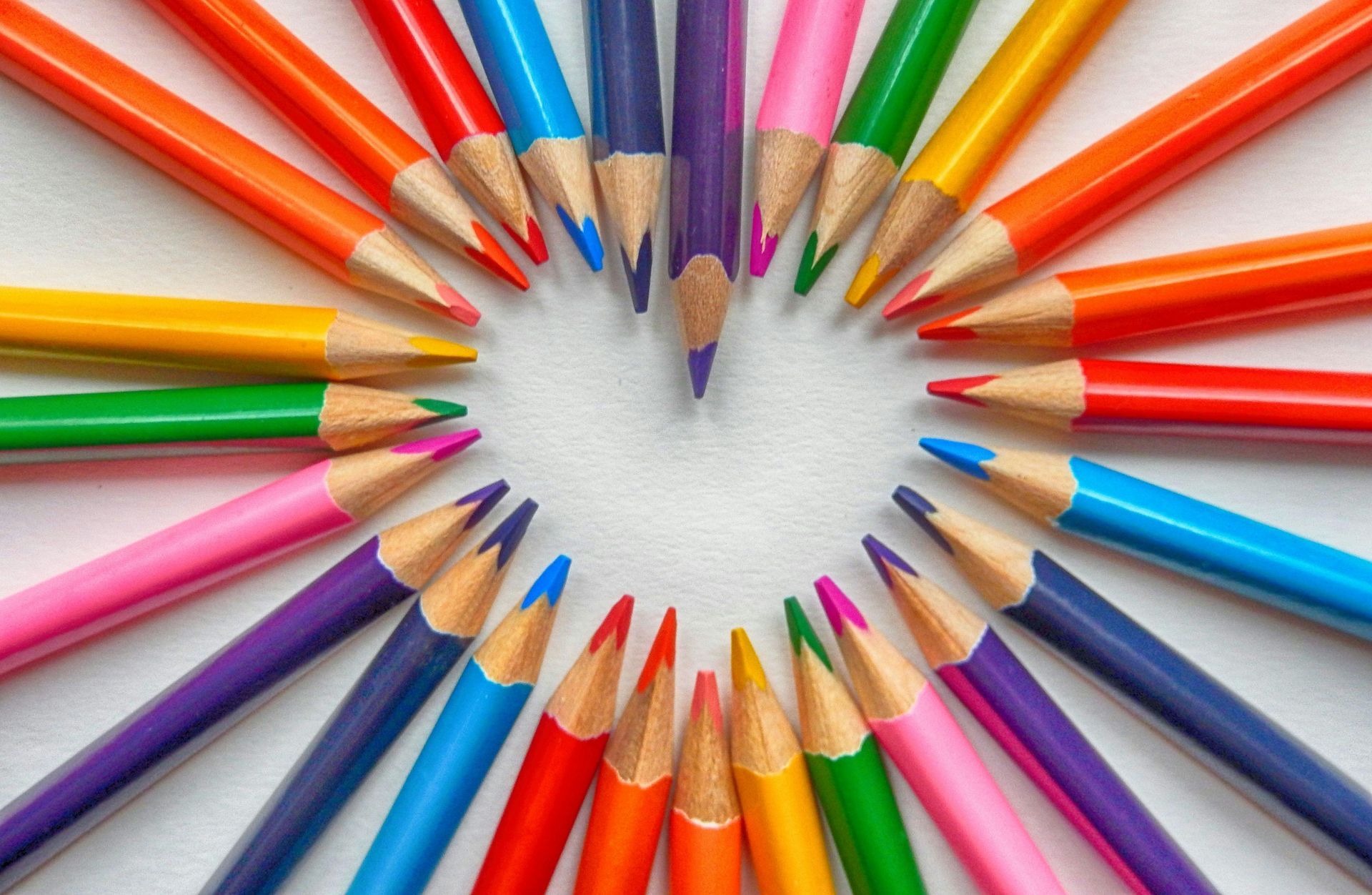A bunch of colored pencils arranged in a heart shape