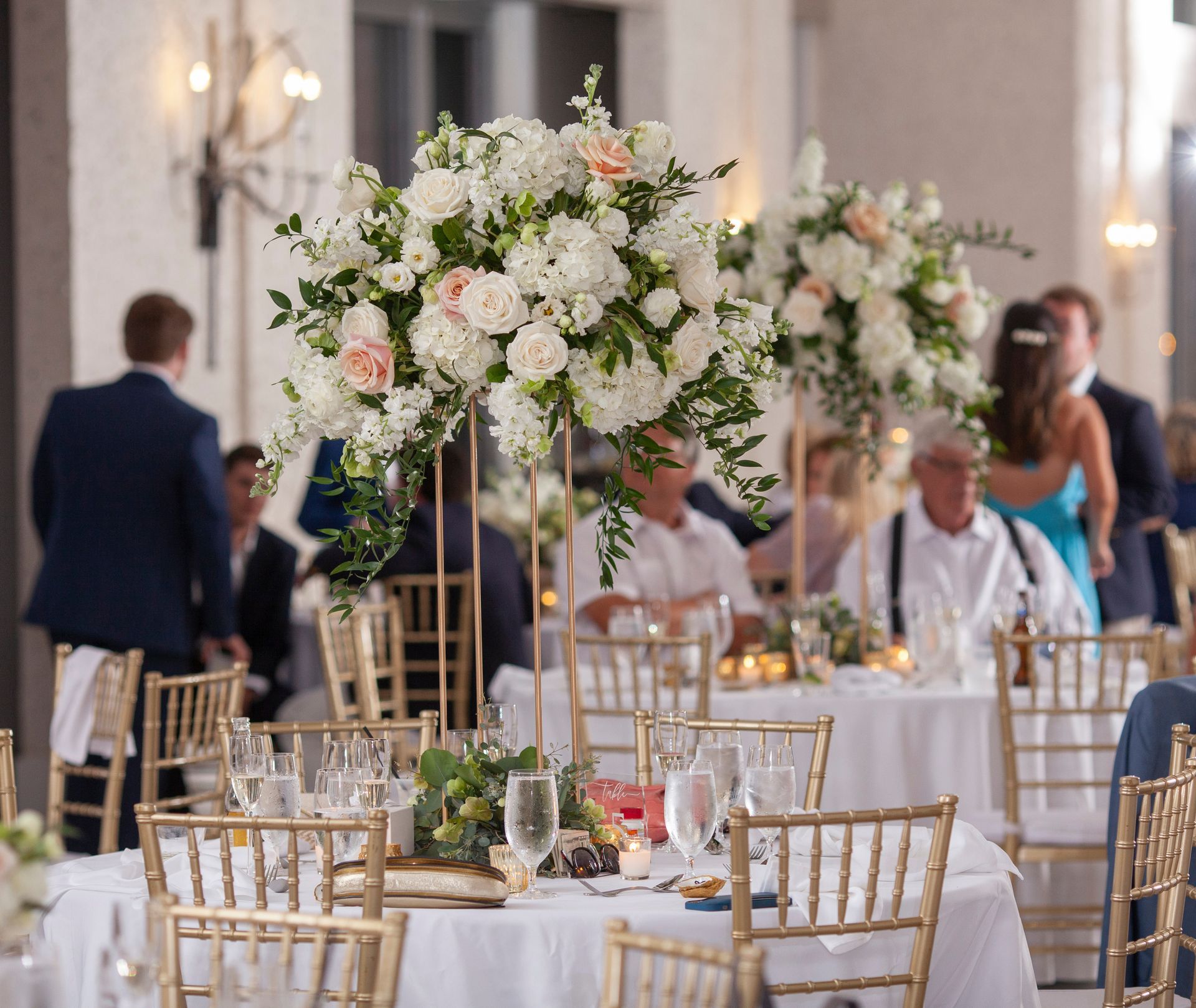 A room filled with tables and chairs with flowers on them