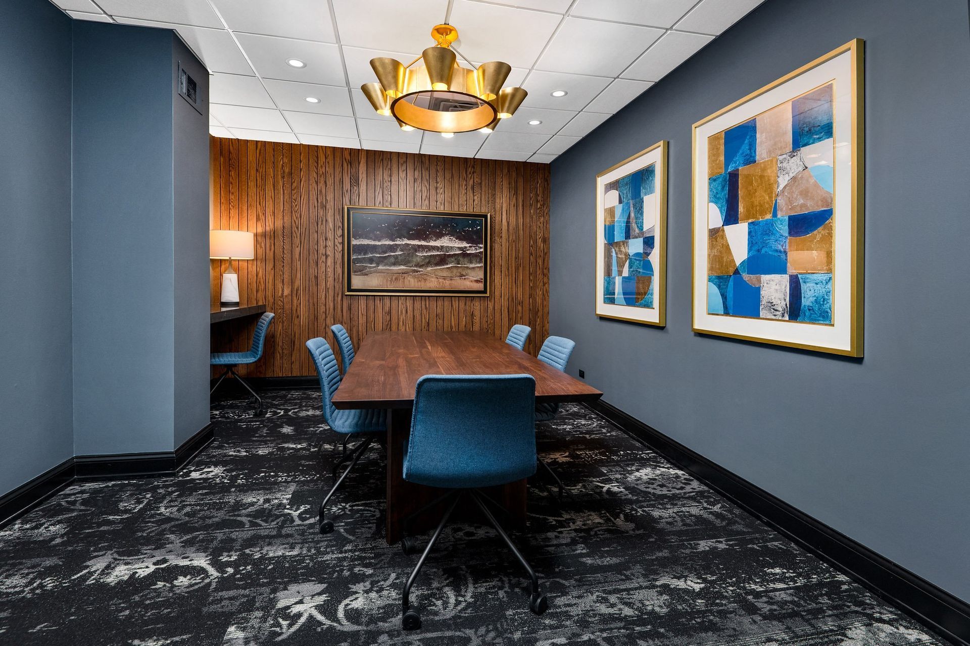 a conference room with a long wooden table and blue chairs