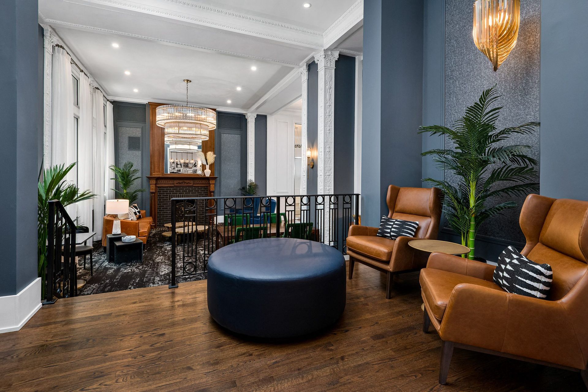 a room with blue walls and wood floors with a large blue ottoman in the middle