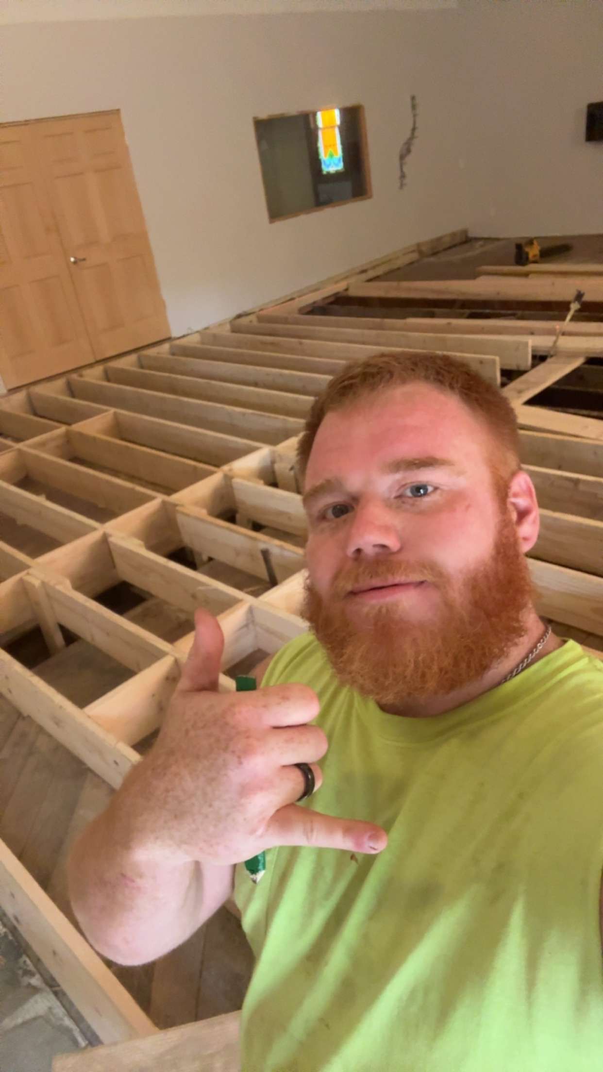 A man with a beard is standing in a room under construction.