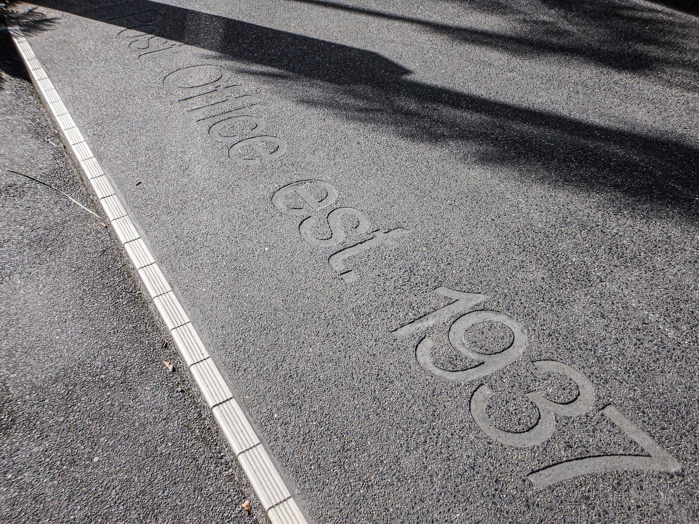 Decorative footpath tile on a Cairns city street, part of a local public historical trail