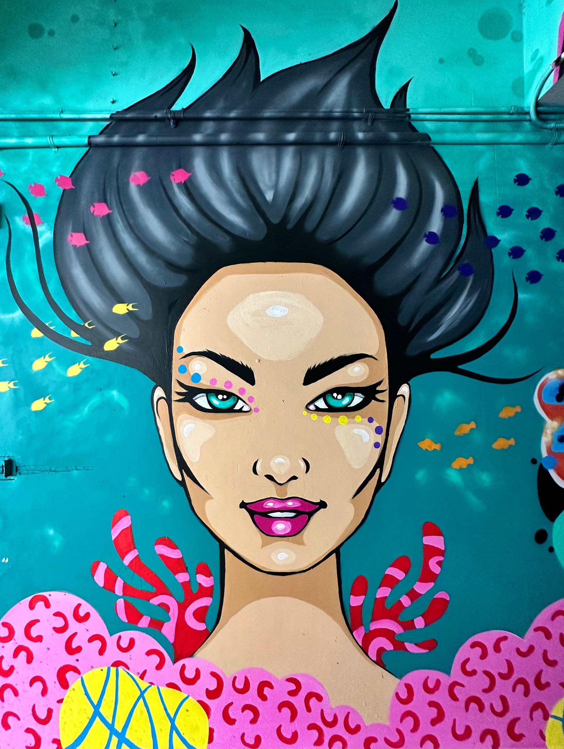 Colourful street art mural created by Caroline Mudge in a hidden Cairns laneway, showcasing local artists and urban culture.