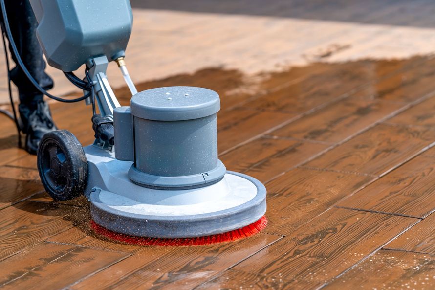 Floor buffer polishing a wooden floor with a red pad