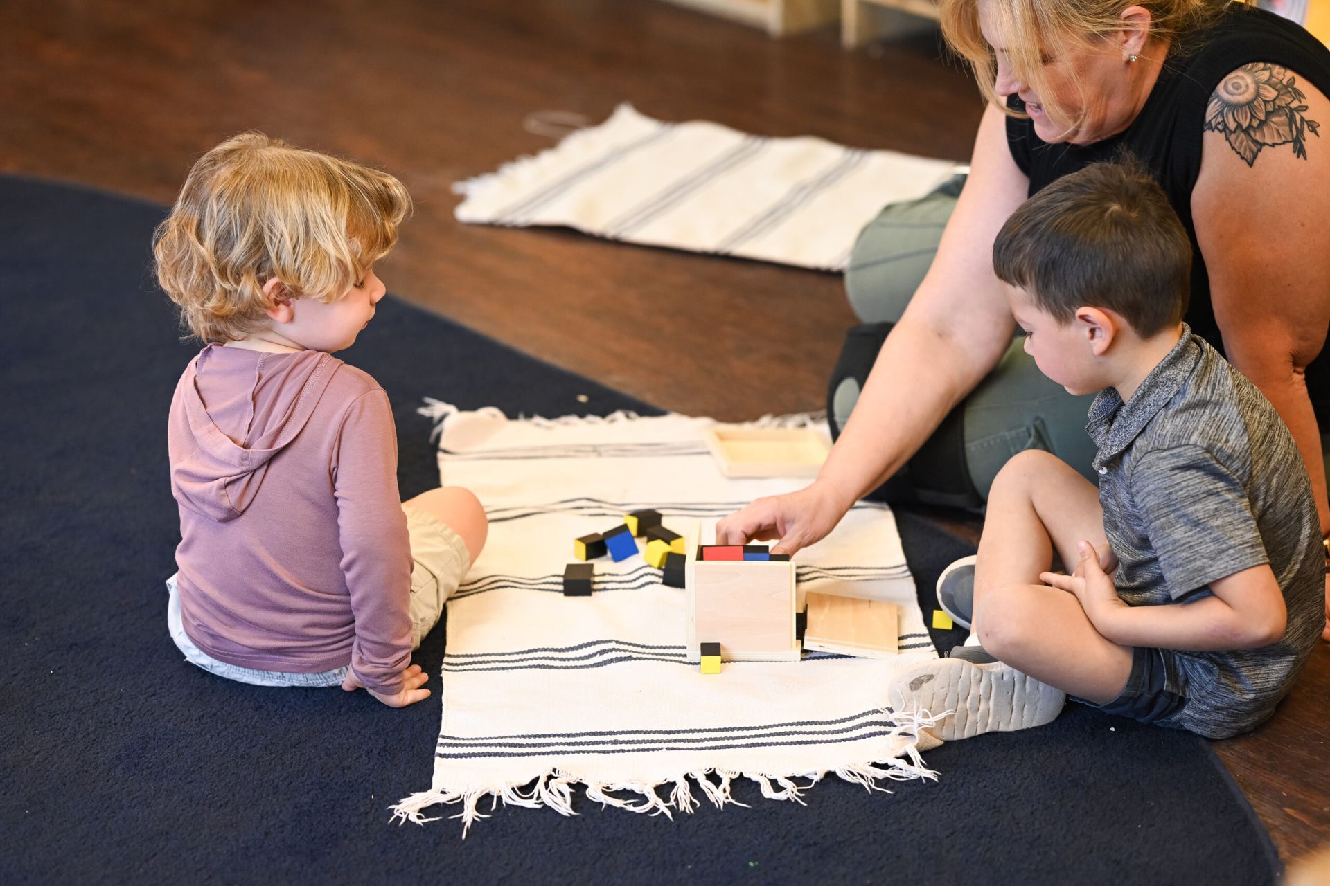 Montessori child and guide working with binomial cube in the classroom