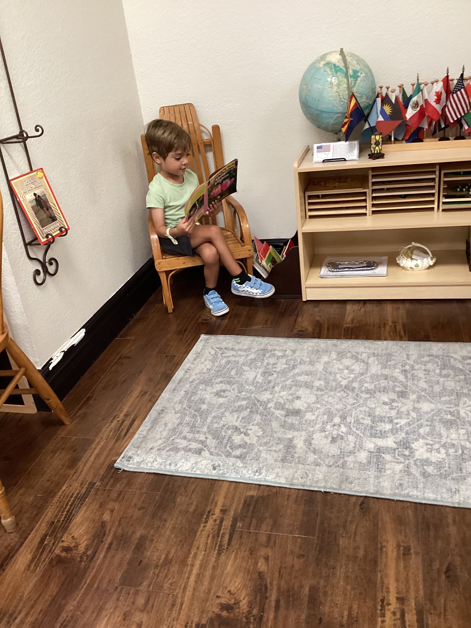 Montessori child reading a book in the classroom