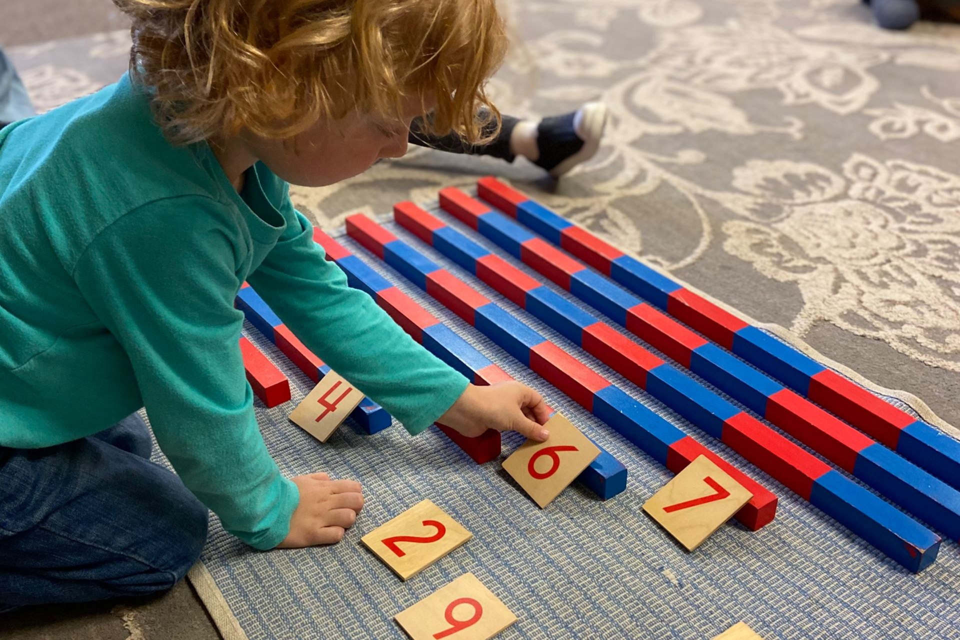 Montessori Toddler is working with number rods and number cards
