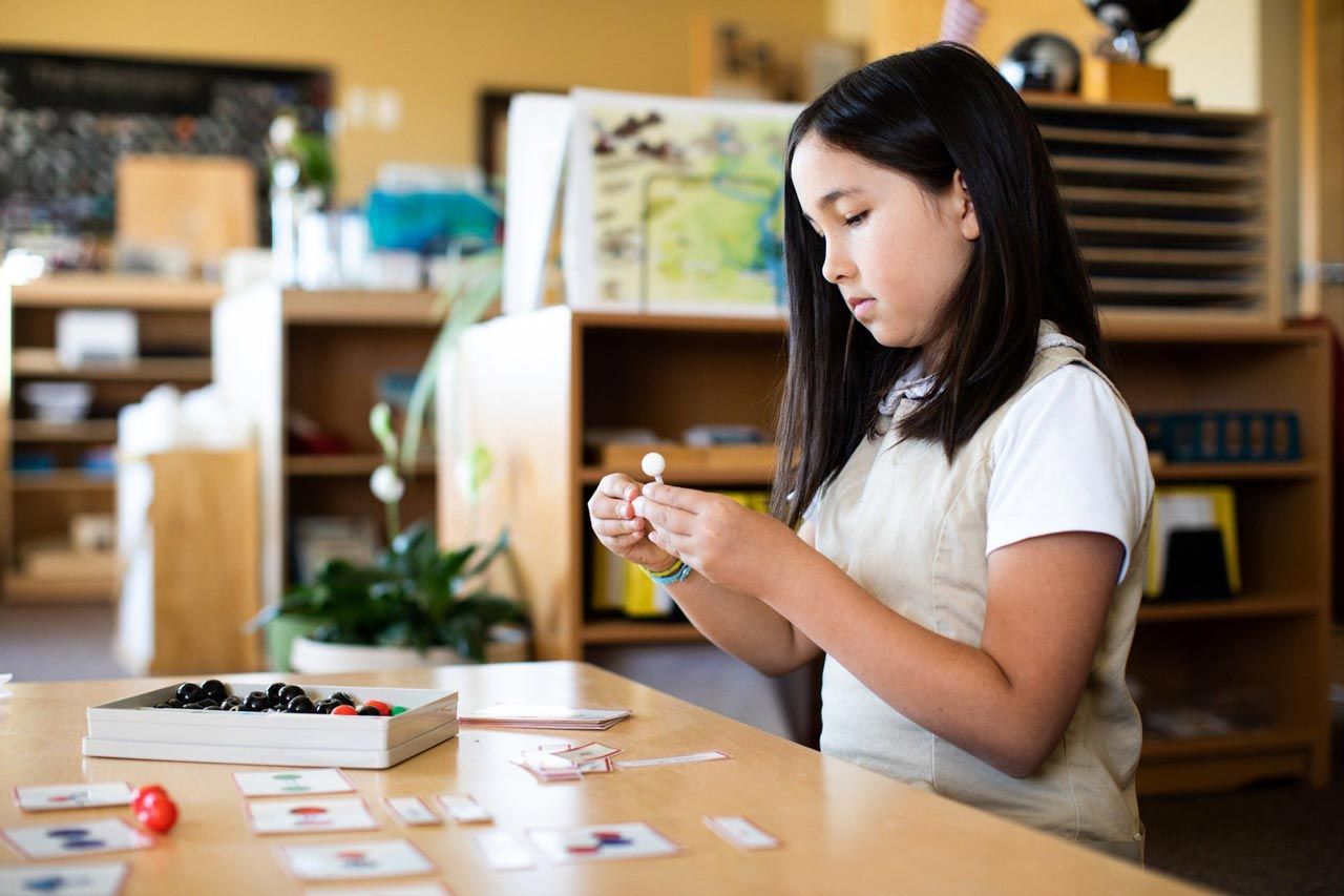 A child is working with Montessori materials.