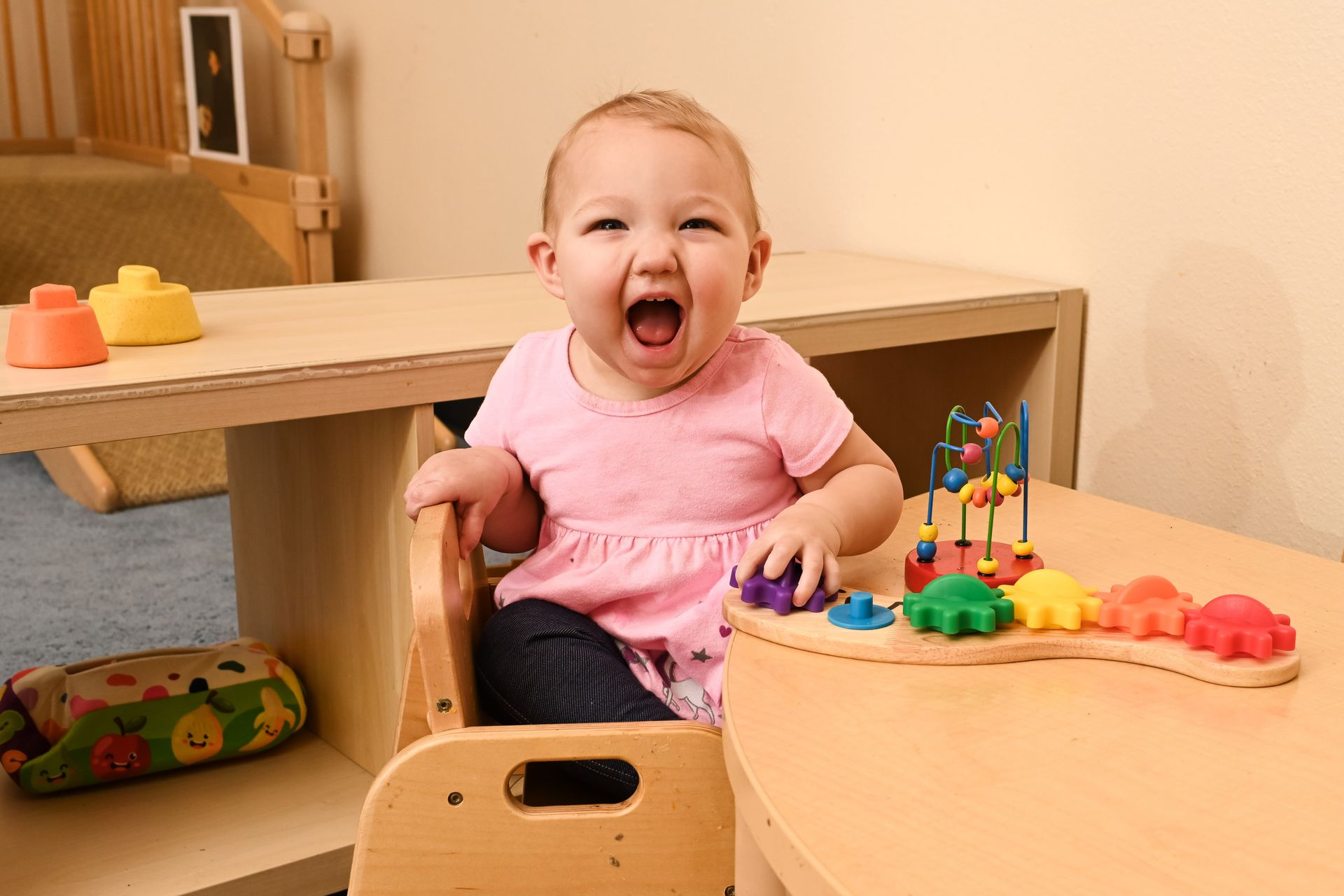 Montessori infant sittingat a table and working with materials.