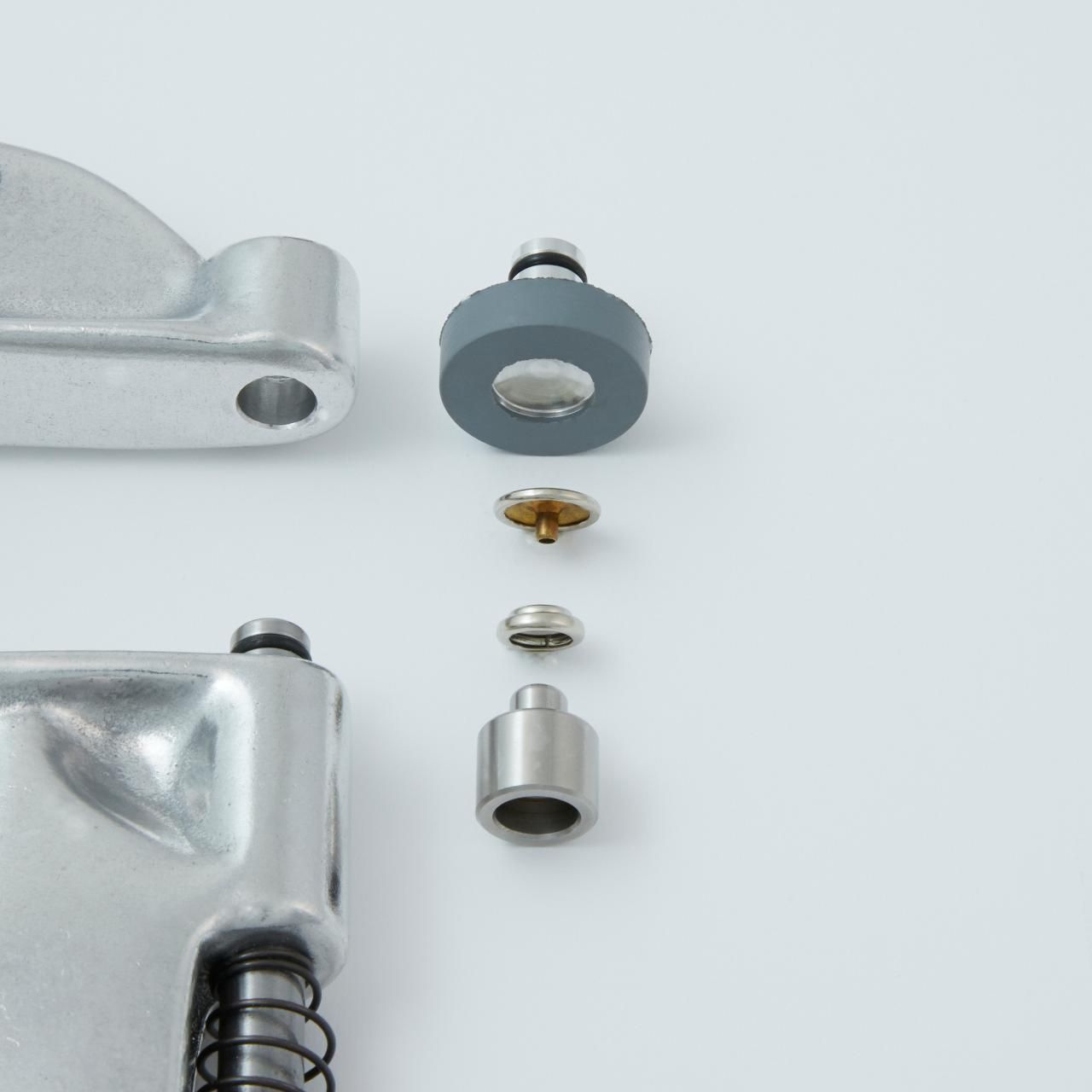 Exploded view of a mechanical component, showing various metal and rubber parts arranged against a white background.