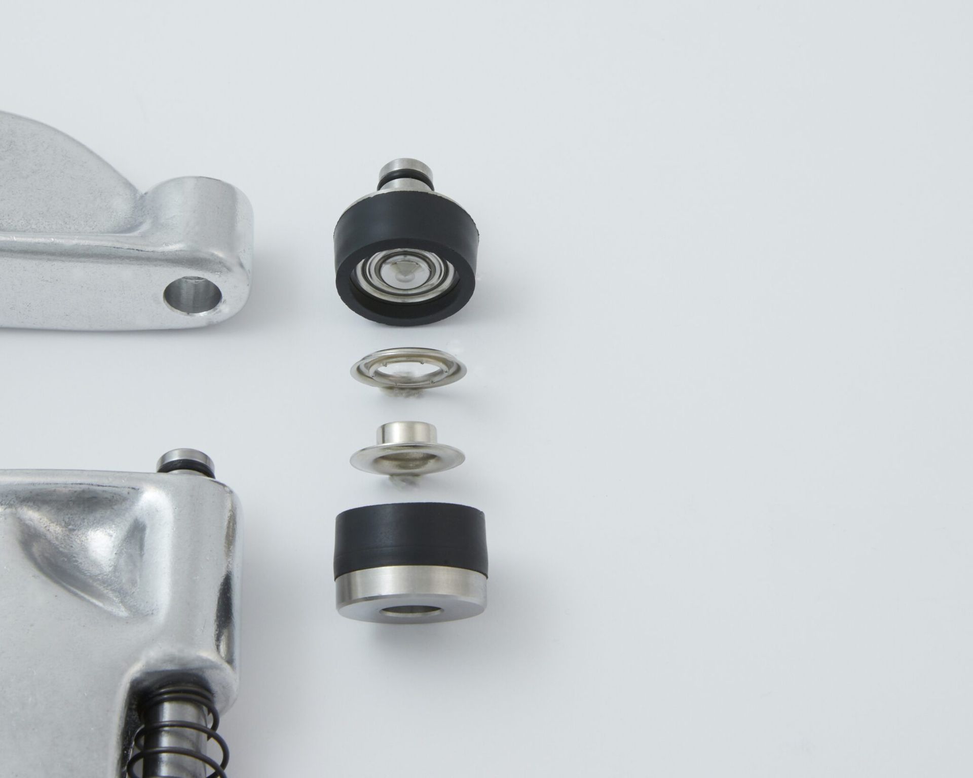 Exploded view of mechanical components, including bearings and rubber elements, against a white backdrop.