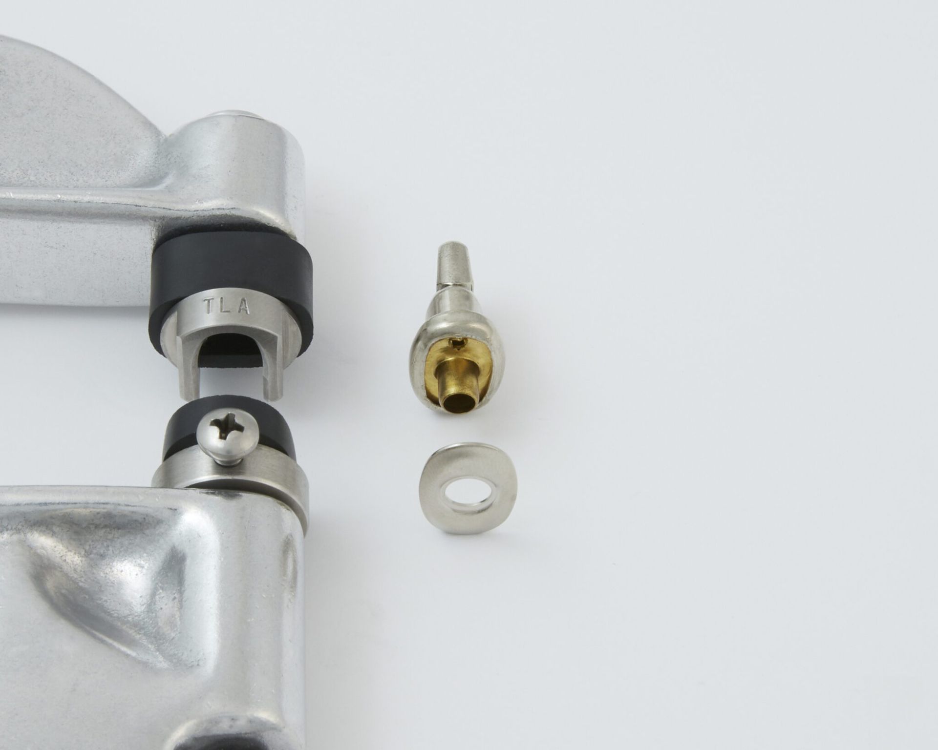 Metal rivet press with parts disassembled: punch, die, washer. White background.