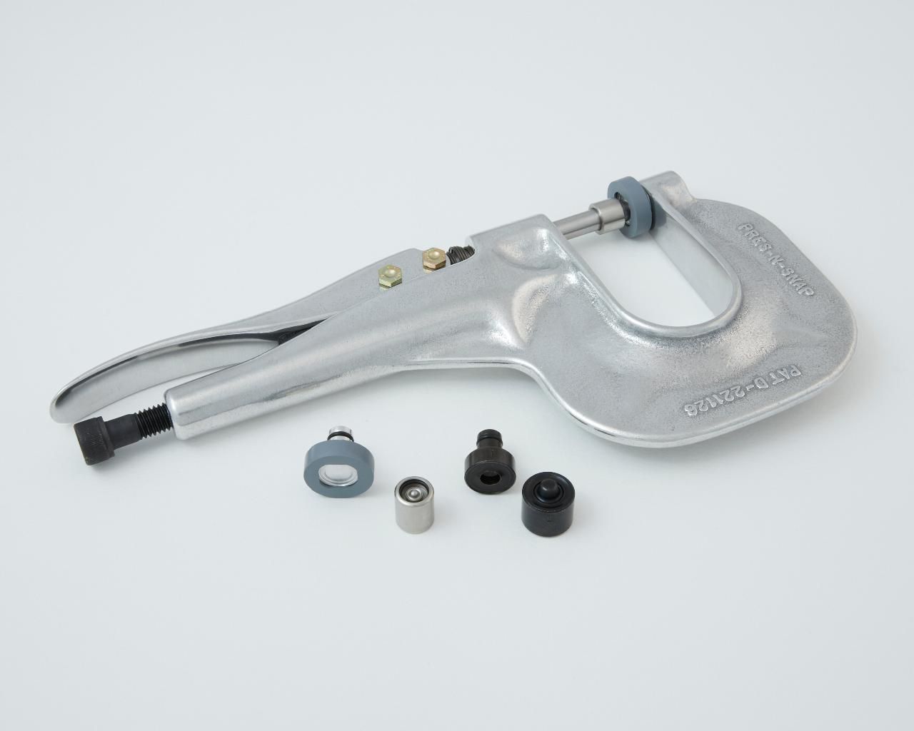 Hand-held metal rivet tool with various attachment pieces.