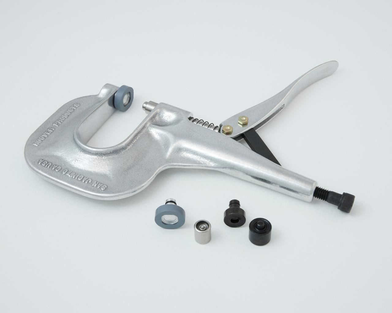 Hand press tool with interchangeable dies for setting rivets or snaps.
