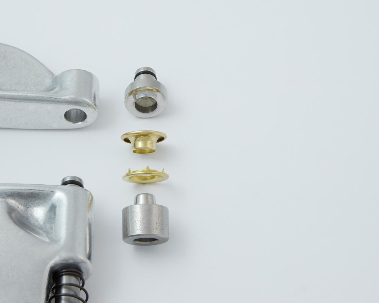 An exploded view of a metal hand press with fastener components.